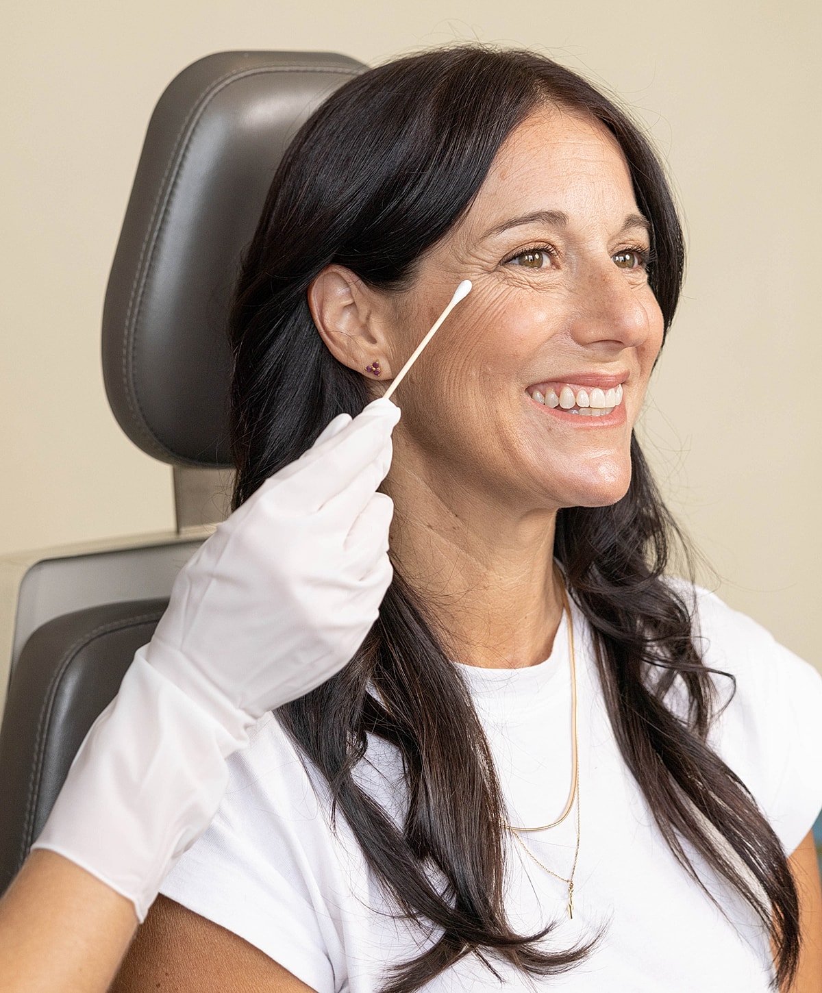 Woman smiling during a skincare treatment consultation.