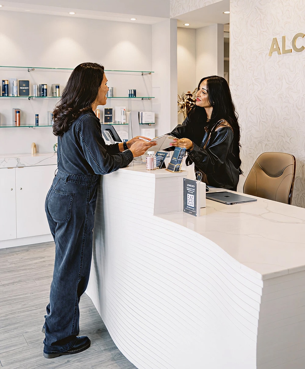 Client at beauty reception desk receiving assistance.